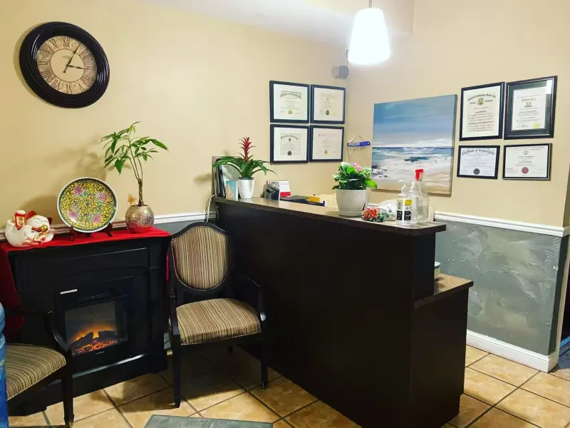 Reception area with framed practitioner registration certificates on the wall